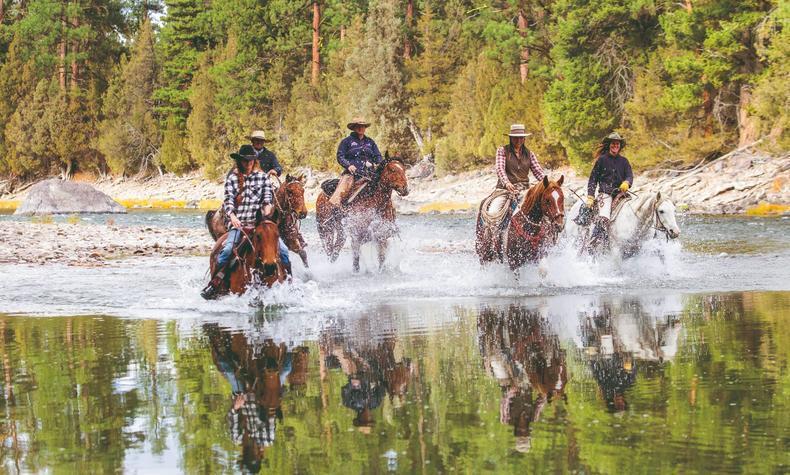 Disfrutar de un paseo a caballo a orillas del río Blackfoot. viaje en familia oeste americano montar a caballo